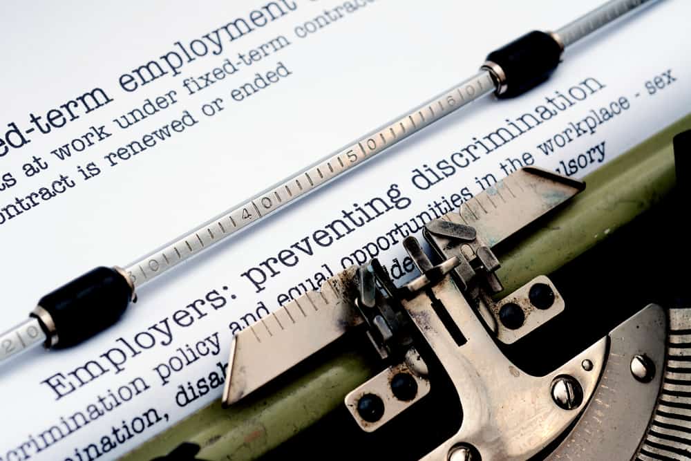 Typewriter with a page that has a few words typed about preventing discrimination
