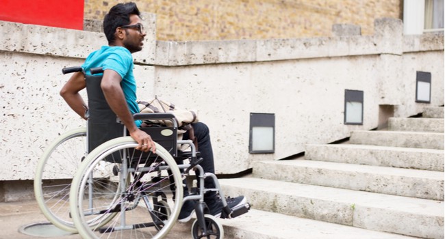 Man in a wheelchair sitting at the bottom of steps