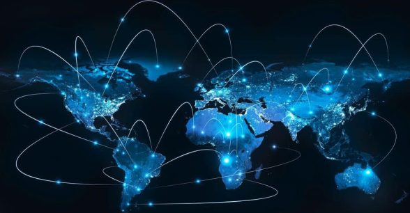 A glowing blue flat map of the world against a black background. There are several points of light, all connected by curved lines to indicate technological connections across the map.