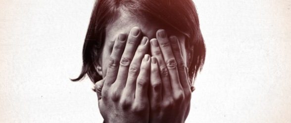 A person covers their face with their hands.