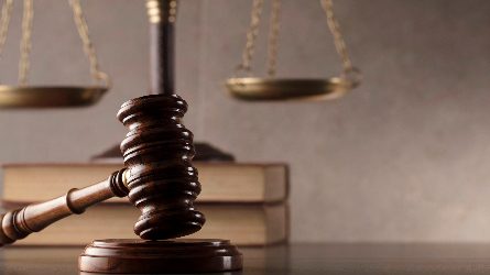 a gavel resting in front of a scale.