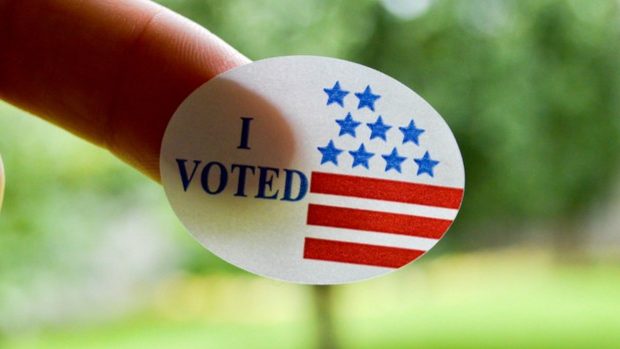 Photo of a person's finger with an "I Voted" sticker stuck to it.