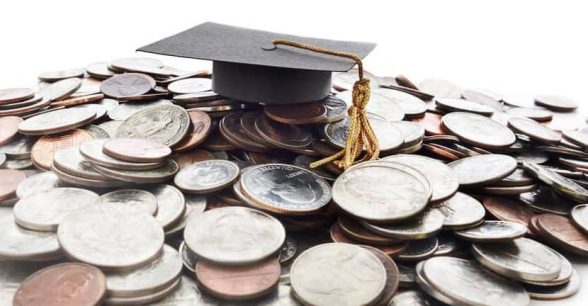 A graduation cap on a pile of American coins.