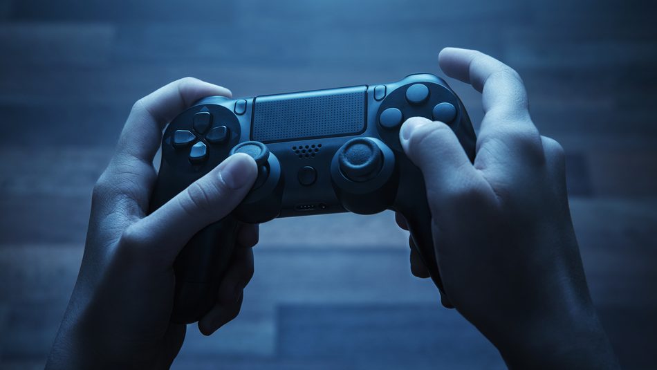 dark-lit photo of a pair of hands holding a video game controller