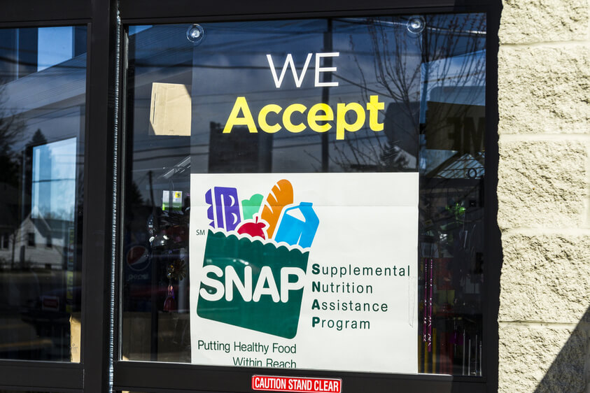 Photo of grocery store window says "we accept SNAP"