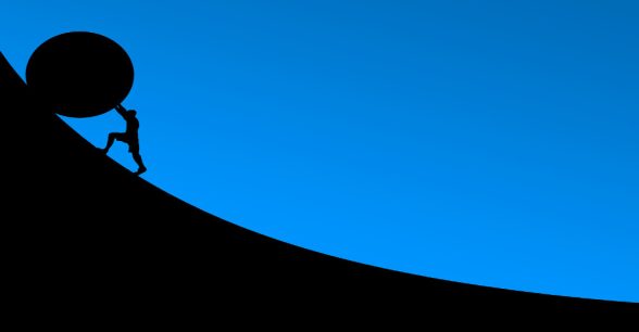 A silhouette of a person pushing a round object that's much bigger than they are up a steep incline.