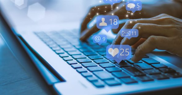 Hands typing on a laptop as notifications pop up