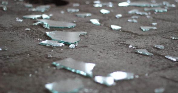 Shards of broken glass scattered on a gray floor.