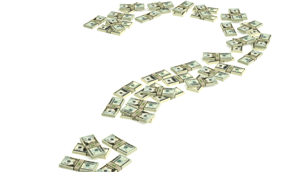 A question mark made out of stacks of U.S. dollar bills.
