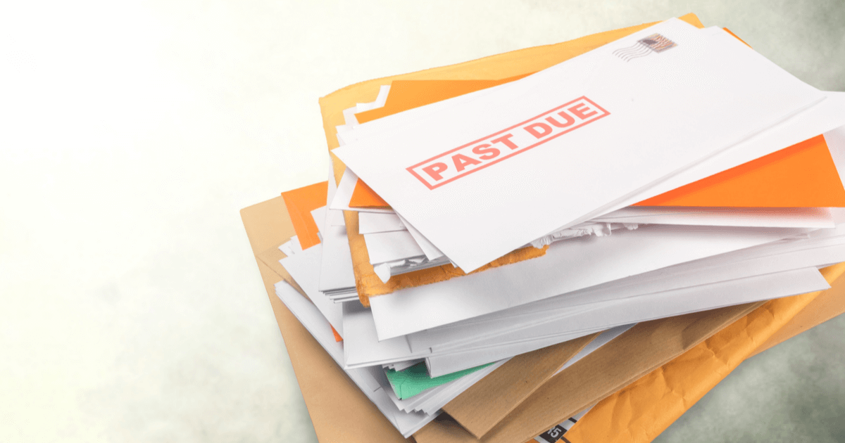 A stack of envelopes with one on the top that says "past due" in bold red letters.