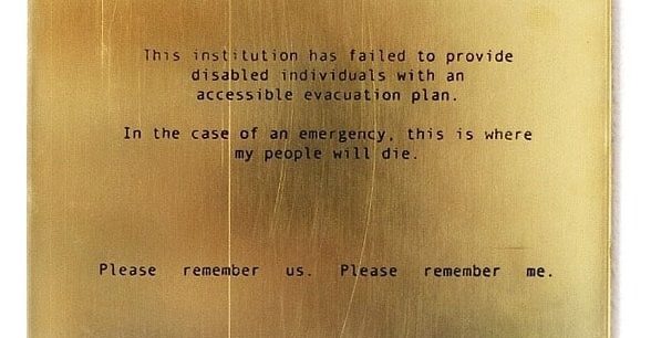 Artwork. A gold plaque has the following written on it in black text: "This institution has failed to provide disabled individuals with an accessible evacuation plan. In the case of an emergency, this is where my people will die. Please remember us. Please remember me."