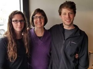 Photo of Debra Kahn and her two children with their arms around each other, smiling.