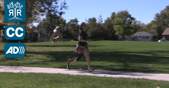 A woman with a prosthetic leg is running on a sidewalk.