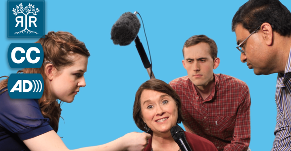 A woman is siting and grinning at the camera while 2 men and a woman are holding microphones at her.