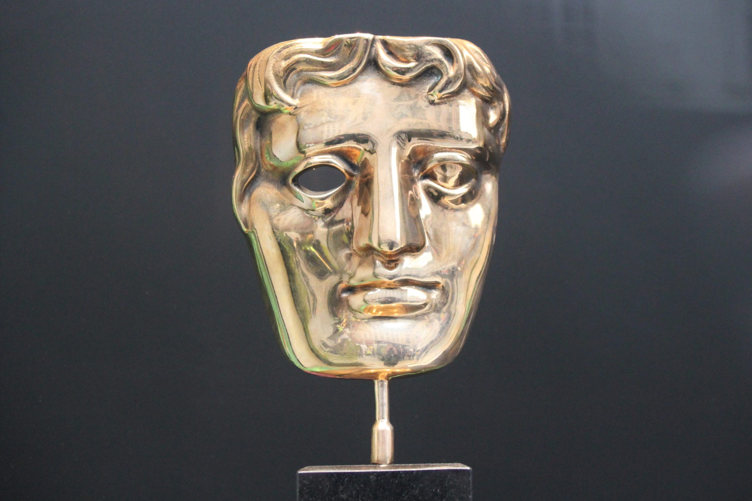 Gold mask shaped BAFTA award.